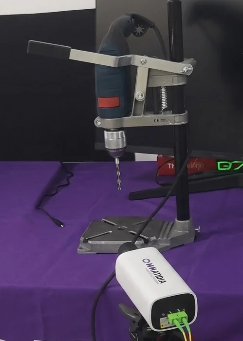 Enhanced close-up of the Qmini observing a drill-bit measurement setup